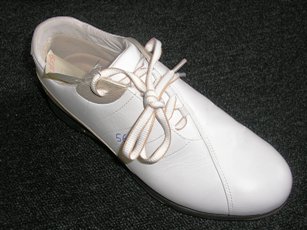 CHAUSSURE DE SPORTS, POUR ADULTES,  AVEC UN DESSUS EN  CUIR (100% CUIR), AVEC UNE SEMELLE EXTERIEURE EN CAOUTCHOUC MAJORITAIRE COMPORTANT SEPT CRAMPONS AMOVIBLES, NE COUVRANT PAS LA CHEVILLE, AVEC UNE SEMELLE INTERIEURE D'UNE LONGUEUR SUPERIEURE A 24 CM. CETTE CHAUSSURE PRESENTE UN SYSTEME D'OUVERTURE PARTIELLE AVEC UN SOUFFLET SUR LE DESSUS SE FERMANT A L'AIDE D'UN LACET.