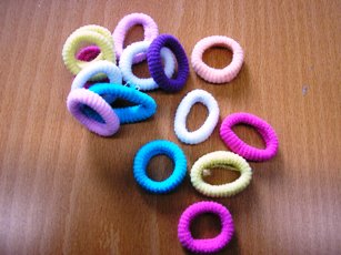 LOT DE TRENTE CINQ ATTACHE POUR CHEVEUX DE TYPE MINI CHOUCHOU EN ETOFFE DE BONNETERIE TUBULAIRE, ELASTIQUE, AYANT LA FORME D'UN ANNEAU, DE DIFFERENTES COULEURS. 
LE TOUT EST CONDITIONNE POUR LA VENTE AU DETAIL DANS UN EMBALLAGE EN MATIERE PLASTIQUE TRANSPARENT..