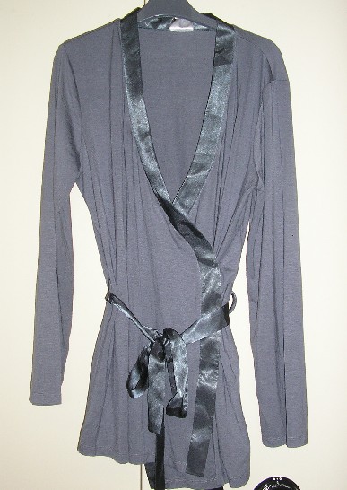 LOT DE TROIS VÊTEMENTS POUR FEMMES, PRESENTES EN ASSORTIMENT CONDITIONNÉS POUR LA VENTE AU DÉTAIL, COMPRENANT UNE VESTE D’INTERIEUR ET UN PANTALON ET UNE BLOUSE CONSTITUANT UN PYJAMA QUI FERA L'OBJET D'UN CLASSEMENT SÉPARÉ.

VETEMENT POUR FEMME, DE STYLE VESTE D’INTERIEUR, EN ETOFFE DE BONNETERIE DE COTON (100% COTON), TEINT UNIFORMEMENT, DE CONTEXTURE LEGERE, ELABOREE, DESTINE A COUVRIR LA PARTIE SUPERIEURE DU CORPS, DESCENDANT JUSQU’AUX HANCHES, DE FORME KIMONO, AVEC UNE ENCOLURE EN « V », AVEC UNE OUVERTURE COMPLETE SUR LE DEVANT SE FERMANT DROITE SUR GAUCHE EN S’ATTACHANT AU MOYEN D’UNE CEINTURE EN SATIN RETENUE PAR DES PASSANTS AU NIVEAU DE LA TAILLE. LE PANNEAU GAUCHE S’ATTACHE A L’INTERIEUR A L’AIDE DE LIENS A NOUER EN SATIN, UN LIEN COUSU A LA COUTURE ET L’AUTRE LIEN AU PANNEAU GAUCHE. LE PANNEAU DROIT VIENT SE SUPERPOSER SUR LE PANNEAU GAUCHE, AVEC DES MANCHES LONGUES POURVUES A LEURS EXTREMITES D’UN OURLET, AVEC UN OURLET A LA BASE DU VETEMENT.

LE POURTOUR DE L’ENCOLURE ET LES PANNEAUX DU DEVANT SONT DOTES D’UN GALON EN SATIN.

LE PYJAMA EST REPRIS SUR LE RTC N°FR-PRO-2008-001687-01.