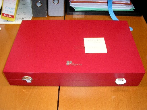 COFFRET EN BOIS, DONT LA SURFACE EXTERIEURE EST RECOUVERTE DE PAPIER ET D'UNE COUCHE DE MATIERE PLASTIQUE PVC, LA PARTIE DE DESSUS SE RABAT SUR LA PARTIE DE DESSOUS, IL COMPORTE DEUX DISPOSITIFS DE FERMETURE, L'INTERIEUR EST AMENAGE DE PLUSIEURS COMPARTIMENTS, IL EST DESTINE A RECEVOIR DES COUVERTS DE TABLE, AVEC LOGO PUBLICITAIRE IMPRIME SUR LA PARTIE DE DESSUS EXTERIEURE ET A L'INTERIEUR.