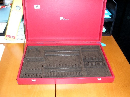 COFFRET EN BOIS, DONT LA SURFACE EXTERIEURE EST RECOUVERTE DE PAPIER ET D'UNE COUCHE DE MATIERE PLASTIQUE PVC, LA PARTIE DE DESSUS SE RABAT SUR LA PARTIE DE DESSOUS, IL COMPORTE DEUX DISPOSITIFS DE FERMETURE, L'INTERIEUR EST AMENAGE DE PLUSIEURS COMPARTIMENTS, IL EST DESTINE A RECECOIR DES COUVERTS DE TABLE.