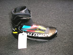 CHAUSSURE POUR LA PRATIQUE DU SKI DE FOND, NON RECONNAISSABLE COMME ETANT POUR HOMME OU POUR FEMME, COUVRANT LA CHEVILLE, AVEC UN DESSUS EN MATIERE PLASTIQUE, AVEC UNE SEMELLE EXTERIEURE EN MATIERE PLASTIQUE, AVEC UNE OUVERTURE SUR LE COTE EXTERIEURE MUNIE D'UNE FERMETURE A GLISSIERE, AVEC UN CHAUSSON INTERIEUR EN ETOFFE DE BONNETERIE REMBOURREE, AVEC UNE LANGUETTE RIGIDE EN MATIERE PLASTIQUE, AVEC DES CROCHETS DE CHAQUE COTE DE LA CHAUSSURE PERMETTANT UNE FERMETURE PAR LACAGE, AVEC UNE LANIERE AU DOS ET SUR LE DEVANT DE LA CHAUSSURE, AVEC UN RENFORT AMOVIBLE EN MATIERE PLASTIQUE MUNI D'UN REMBOURRAGE AU TALON A FIXER A LA CHAUSSURE PAR UN POINT D'ATTACHE DE CHAQUE COTE DE LA CHEVILLE MUNIE D'UNE PATTE ET D'UNE ATTACHE DE SECURITE SUR LE DEVANT DE LA CHEVILLE.  LA SEMELLE EXTERIEURE COMPORTE UN SYSTEME D'ATTACHES AVEC DEUX BARRES EN METAL. CETTE CHAUSSURE COMPORTE LA MARQUE SUR LES COTES ET L'ARRIERE, AINSI QUE SUR LA PATTE SE SITUANT SUR LA CHEVILLE