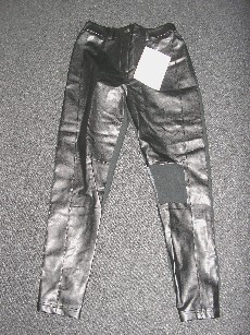 PANTALON POUR FEMMES, CONFECTIONNE EN MATIERE PLASTIQUE , GENRE FAUX CUIR, SUR LE DEVANT ET EN BONNETERIE MAJORITAIREMENT DE FIBRES ARTIFICIELLES (100% VISCOSE) A L'ARRIERE, DESCENDANT JUSQU'AUX CHEVILLES EN ENVELOPPANT SÉPARÉMENT CHAQUE JAMBE, AVEC UN ELASTIQUE A LA TAILLE AU NIVEAU DU DOS ET DES POCHES ARRIERE, AVEC UNE OUVERTURE PARTIELLE FERMANT PAR UNE FERMETURE A GLISSIERE SOUS UNE PATTE FERMANT DROITE SUR GAUCHE PAR UN BOUTON.     

TAILLE 40