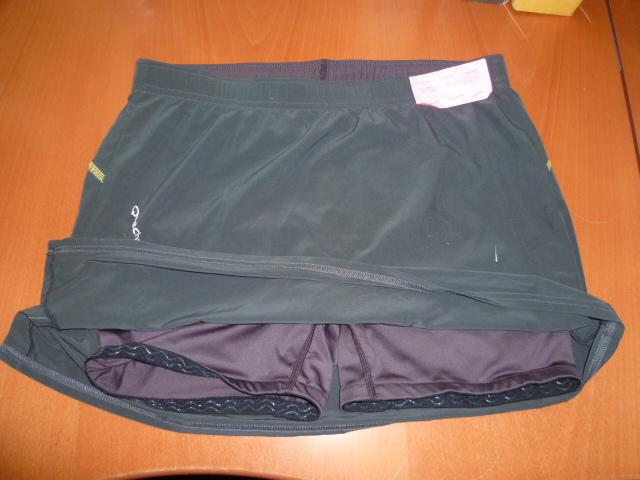 VETEMENT DESTINE A RECOUVRIR LA PARTIE INFERIEURE DU CORPS,GENRE JUPE TRES COURTE,CONFECTIONNEE EN TISSU DE FIBRES SYNTHETIQUES,AVEC UNE TAILLE ELASTIQUEE DOTÉE A L'INTERIEUR D'UN CORDON RESSERRANT. LA JUPE COMPORTE UN SHORT INTÉGRÉ NON SEPARABLE CONFECTIONNÉ EN BONNETERIE DE FIBRES SYNTHETIQUES, MAINTENU AUX CUISSES AU MOYEN DE DEUX BANDES ELASTIQUEES ENDUITES DE SILICONE.