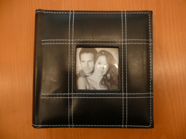 UN ALBUM POUR PHOTOGRAPHIES COMPRENANT UNE COUVERTURE EN MATIERE PLASTIQUE MUNIE SUR LE DESSUS DE SURPIQURES ET D'UNE OUVERTURE, DE FORME CARREE, PERMETTANT D'INSERER UNE PHOTOGRAPHIE ET DES FEUILLES EN PAPIER RECOUVERTES D'UN FILM PLASTIQUE POUR L'INSERTION DE PHOTOGRAPHIES.

DIMENSION 23 X 22 CM