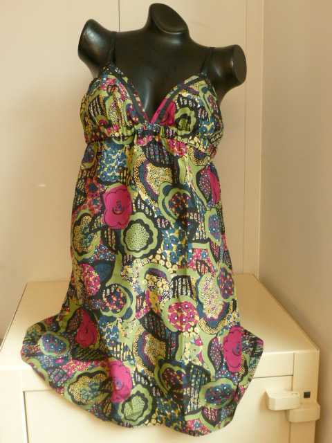 VETEMENT POUR FEMME, GENRE BLOUSE, EN TISSU DE SOIE (100% SOIE), IMPRIME, DE FACTURE AMPLE ET FLUIDE, DESTINE A COUVRIR LA PARTIE SUPERIEURE DU CORPS ET DESCENDANT JUSQU'A MI-CUISSES. L'ARTICLE COMPORTE DEUX FINES BRETELLES REGLABLES, UN DECOLLETE EN V, UN RUBAN EN TISSU COUSU SUR TOUT LE POURTOUR DE L'ENCOLURE, UN ELASTIQUE A L'INTERIEUR DU VETEMENT FAISANT LE TOUR EN DESSOUS DE LA POITRINE, ET UN OURLET A LA BASE. 
LONGUEUR ENVIRON 82 CM. 
TAILLE : 40.