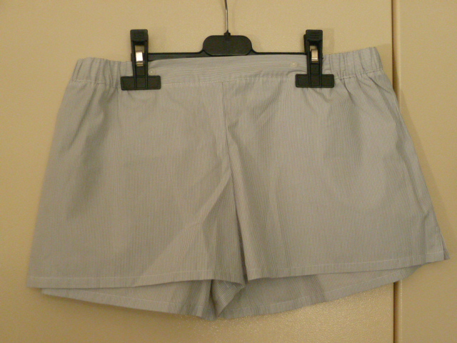 SHORT, NON RECONNAISSABLE COMME ETANT POUR HOMME OU POUR FEMME, CONFECTIONNE EN TISSU 100% COTON, AVEC UN MOTIF A RAYURES, ET DE FACTURE AMPLE. 
L'ARTICLE COMPORTE UN ELASTIQUE A LA TAILLE AVEC DEUX BOUTONS DECORATIFS SUR LE DEVANT, UNE POCHE ARRIERE DROITE SANS FERMETURE, DEUX FENTES LATERALES ET UN OURLET A LA BASE.
