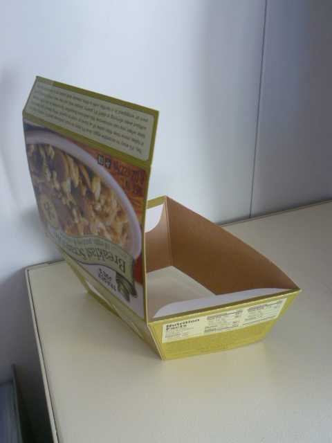 EMBALLAGE EN CARTON PRESENTÉ A PLAT.
LE MONTAGE RESULTE DU SIMPLE PLIAGE DES DIFFERENTES PARTIES SOLIDAIRES LES UNES DES AUTRES, L’EMBALLAGE PLIÉ CONSTITUE UNE BOITE DE FORME PARALLEPIPEDE MUNIE D'UN COUVERCLE ET SANS FOND.
ELLE POSSEDE SUR TOUTES LES FACES DES INSCRIPTIONS.
CETTE BOITE EST DESTINÉE A CONTENIR UNE PREPARATION ALIMENTAIRE