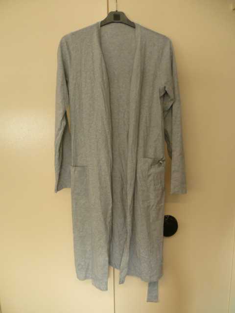 VETEMENT, SIMILAIRE A UNE ROBE DE CHAMBRE, DESTINE A RECOUVRIR LA PARTIE SUPERIEURE DU CORPS, DESCENDANT JUSQU'AU DESSUS DES GENOUX, DE FORME KIMONO, CONFECTIONNE EN ETOFFE DE BONNETERIE DE COTON (100 % COTON), TEINTE UNIFORMEMENT ET NON RECONNAISSABLE COMME ETANT POUR HOMME OU POUR FEMME. 
CET ARTICLE PRESENTE UNE ENCOLURE EN V, UNE OUVERTURE COMPLETE SUR LE DEVANT SE FERMANT AU MOYEN D'UNE CEINTURE RETENUE PAR DEUX PASSANTS, DES MANCHES LONGUES SE TERMINANT PAR UN OURLET, DEUX POCHES LATERALES DONT L'UNE EST MUNIE D'UN NOEUD DECORATIF ET D'UNE PETITE PLAQUE RONDE REPRENANT LE NOM DE LA MARQUE, UNE BANDE RAPPORTEE LE LONG DE L'OUVERTURE, ET UN OURLET A LA BASE.