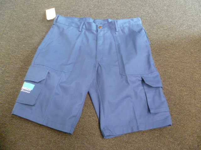 VETEMENT DESTINE A RECOUVRIR LA PARTIE INFERIEURE DU CORPS, DE TYPE SHORT (BERMUDA), CONFECTIONNE EN TISSU DE COTON MAJORITAIREMENT(60% COTON, 40% POLYESTER) DESCENDANT JUSQU'AU-DESSUS DES GENOUX. 
CE VETEMENT COMPORTE DES PASSANTS A LA TAILLE, UNE OUVERTURE PARTIELLE SUR LE DEVANT SE FERMANT AU MOYEN D'UNE FERMETURE A GLISSIERE SOUS UNE PATTE DE PROTECTION MAINTENUE GAUCHE SUR DROITE PAR UN BOUTON, UNE POCHE LATERALE DE CHAQUE COTE DES HANCHES, UNE POCHE A SOUFFLET SUR CHAQUE CUISSE AVEC UN RABAT ET UNE BANDE AUTOAGRIPPANTE, UNE POCHE ARRIERE AVEC UNE PATTE ET UNE BANDE AUTOAGRIPPANTE, ET LA MARQUE INSCRITE SUR LA CUISSE DROITE. LA BASE EST OURLEE.   

TAILLE 48