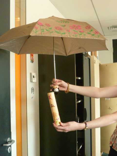 PARAPLUIE A MANCHE TELESCOPIQUE POURVU D'UNE TOILE DE TISSU, DONT UN DES PANNEAUX COMPORTE DES MOTIFS DECORATIFS, D'UN MANCHE ET DE BALEINES EN METAL AVEC UNE POIGNEE EN PLASTIQUE REPRESENTANT UNE TETE DE FEMME D'ORIGINE ASIATIQUE. LE PARAPLUIE SE RANGE DANS UN CYLINDRE EN PLASTIQUE DECORE DE FACON A REPRESENTER UN KIMONO. MODELE EXISTANT EN PLUSIEURS COULEUR BLEU, ROSE, VIOLET, BLANC, JAUNE OU ROUGE ET PRESENTE POUR LA VENTE AU DETAIL DANS UN EMBALLAGE CARTONNE.