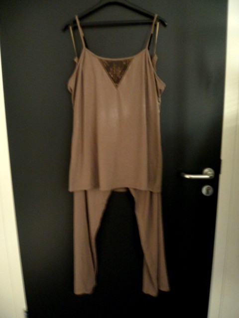 PYJAMA POUR FEMME, CONFECTIONNE EN ETOFFE DE BONNETERIE 60% POLYESTER, 36% VISCOSE ET 4% SPANDEX, D'UN COLORIS UNI, COMPRENANT:

-UN TOP, SANS MANCHES, AVEC UNE ENCOLURE ARRONDIE, DE FINES BRETELLMES REGLABLES, LA BASE DU VETEMENT SE TERMINE PAR UN OURLET, AVEC UNE DECORATION DENTELLE AU CENTRE DE LA POITRINE.

-UN PANTALON LARGE, SANS OUVERTURE, AVEC UNE TAILLE ELASTIQUEE, UN OURLET A LA BASE DES JAMBES.

CE PYJAMA EST ACCOMPAGNE POUR LA VENTE AU DETAIL D'UNE VESTE D'INTERIEUR QUI FAIT L'OBJET D'UN CLASSEMENT SEPARE: FR-PRO-2011-005975-02.