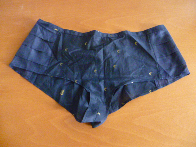 CULOTTE À TAILLE HAUTE GENRE SHORTY POUR FEMMES, EN TISSU MAJORITAIREMENT DE COTON (65% COTON – 33% SOIE – 2% LUREX ),  COMPORTANT UNE OUVERTURE A L'ARRIERE SE FERMANT PAR UN BOUTON, AVEC TROIS RANGEES DE VOLANT SUR LES COTES, AUCUNE DOUBLURE INTERIEURE.