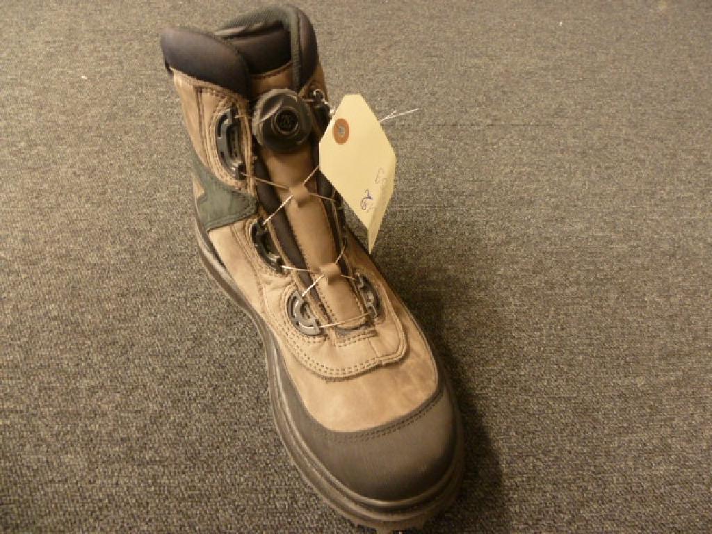CHAUSSURE DE PÊCHE, NON RECONNAISSABLE COMME ETANT POUR HOMMES OU POUR FEMMES, COUVRANT LA CHEVILLE, MAIS PAS LE MOLLET, DONT LE DESSUS EST EN CUIR AVEC UNE LANGUETTE SUR LAQUELLE EST FIXÉ UN DISPOSITIF PERMETTANT DE SERRER OU DESSSÉRER LA CHAUSSURE PAR UN FIL MÉTALLIQUE COULISSANT, LA SEMELLE EXTERIEURE EST EN CAOUTCHOUC ET PRESENTE DES CRAMPONS, LA SEMELLE INTERIEURE MESURE 29 CM. CETTE CHAUSSURE PRÉSENTE SUR LE CÔTÉ GAUCHE AU NIVEAU DE LA CHEVILLE UN LOGO “JMC”.