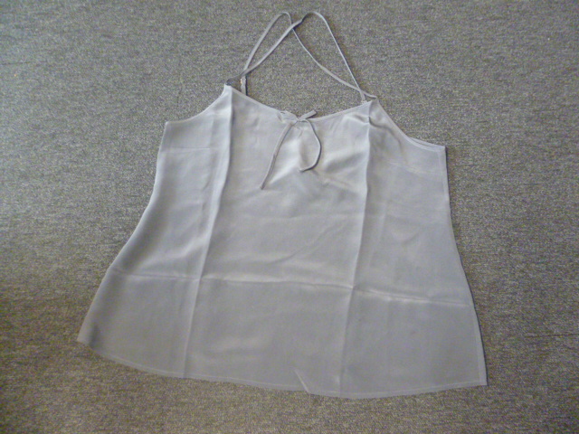 VETEMENT POUR FEMME, GENRE BLOUSE, COUPE EN BIAIS,  EN TISSU DE SOIE (100% SOIE) DESTINE A COUVRIR LA PARTIE SUPERIEURE DU CORPS, DESCENDANT JUSQU'EN HAUT DES CUISSES, AVEC DEUX FINES BRETELLES REGLABLES, SE CROISANT DANS LE DOS, AVEC UNE ENCOLURE ARRONDIE  SUR LE DEVANT GARNIE D’UN CORDON EN FORME DE NOEUD AU NIVEAU DE L'ENCOLURE,  A LA BASE DU VETEMENT UNE FINE COUTURE.