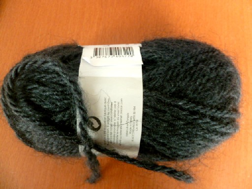 PELOTE DE FIL A TRICOTER, COMPOSEE D'UN FIL A 3 BRINS, EN FIBRES SYNTHETIQUES DISCONTINUES, 57% ACRYLIQUE, 24% POLYAMIDE ET 19% LAINE, D'UN TITRE DE 10290 DECITEX, ET D'UNE MASSE NETTE DE 50.6 GR.