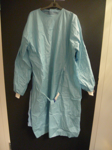 BLOUSE CHIRURGICALE (CASAQUE), DESCENDANT JUSQU'AU DESSOUS DES MOLLETS, CONFECTIONNEE PRINCIPALEMENT EN FIBRES DE SPUNLACE ET SMS NONTISSES. CE VETEMENT COMPORTE UNE ENCOLURE RAS-DE-COU, DES MANCHES LONGUES PRESENTANT UN BORD-COTE EN MATIERE TEXTILE A LEUR EXTREMITE ET UNE OUVERTURE COMPLETE SE FERMANT PAR UNE BANDE VELCRO AU NIVEAU DU COU ET PAR DEUX LIENS AU NIVEAU DE LA TAILLE. CET ARTICLE EST ACCOMPAGNE DE DEUX ESSUIE-MAINS.