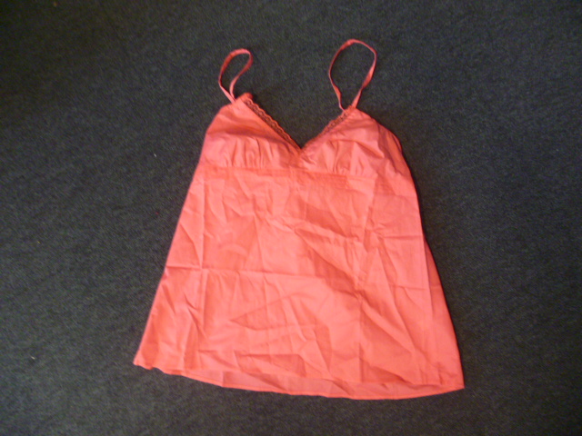 VETEMENT POUR FEMME, GENRE BLOUSE-CARACO, 100% COTON,  DESTINE A RECOUVRIR LA PARTIE SUPERIEURE DU CORPS, DESCENDANT JUSQU'A LA TAILLE, AVEC DE FINES LANIERES REGLABLES, UNE ENCOLURE EN V SURMONTEE DE DENTELLE, AVEC UN ELASTIQUE DANS LE DOS  ET TROIS VOLANTS SUR LE DEVANT, AVEC UN OURLET A LA BASE.