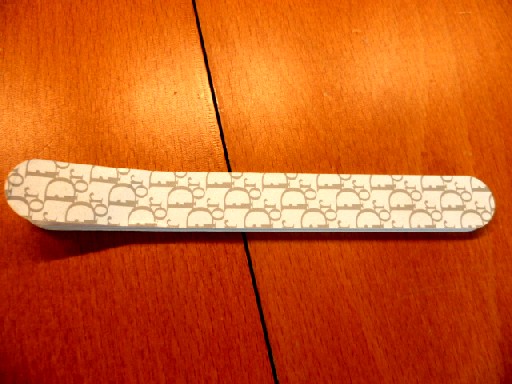 LIME A ONGLES, COMPOSEE D'UNE PLAQUE DE MATIERE PLASTIQUE, RECOUVERTE SUR CHAQUE FACE D'UNE MOUSSE DE MATIERE PLASTIQUE ET D'UN PAPIER RECOUVERT D'UNE POUDRE ABRASIVE, AVEC LE LOGO DE LA MARQUE IMPRIME SUR LES DEUX FACES.