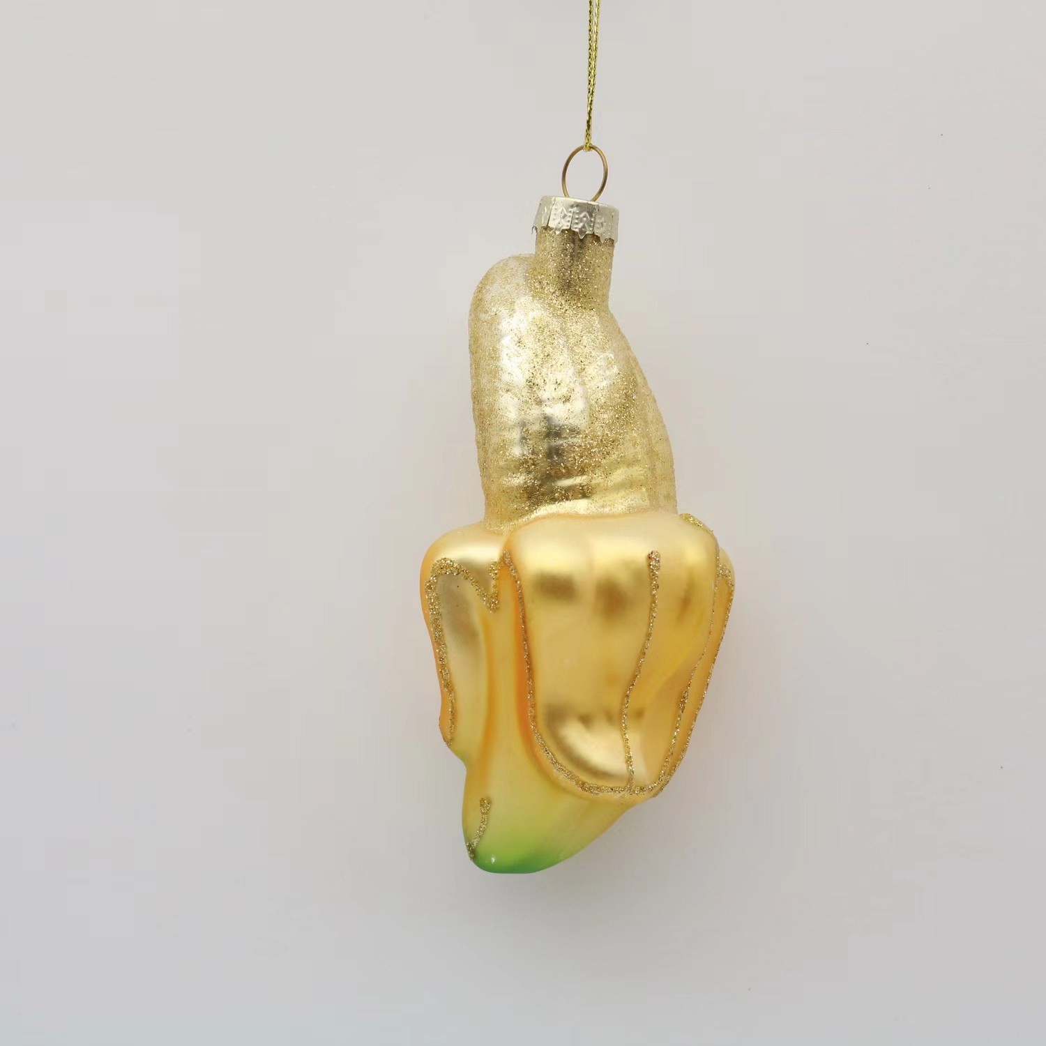 Article destiné à la décoration des arbres de Noël sous la forme d'une banane épluchée en verre à suspendre.
L 6.5 × D 5.3× H 12.1cm