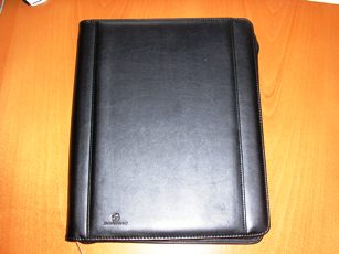 PORTE-DOCUMENTS DE TYPE CONFERENCIER, DE FORMAT 27,5 X 33 X 3,5 CM, A SURFACE EN FEUILLE DE MATIERE PLASTIQUE GRAINEE (POLYCHLORURE DE VINYLE) RENFORCEE  EN SON MILIEU, AVEC UNE FERMETURE A GLISSIERE SUR SON POURTOUR ET UNE GRANDE POCHE EXTERIEURE. CET ARTICLE PRESENTE A L'INTERIEUR :  
- SUR LA PARTIE DROITE , UN RABAT DANS LEQUEL EST INSERE UN BLOC DE PAPIER AMOVIBLE, 
- AU CENTRE DEUX PASSANTS ELASTIQUES POUR MAINTENIR DES STYLOS, 
- SUR LA PARTIE GAUCHE, UNE GRANDE POCHE A SOUFFLET, UNE GRANDE POCHE AVEC UNE FERMETURE A GLISSIERE, UN BLOC DE PETITES POCHES DONT UNE AVEC UN RECTANGLE DE MATIERE PLASTIQUE TRANSPARENT, POUR RANGER DIVERS DOCUMENTS, UNE POCHE POUR RANGER UN TELEPHONE PORTABLE, ET UNE BANDE VELCRO.