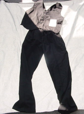 MENS WOVEN ENSEMBLE. CONSISTING OF AN UPPER GARMENT WHICH IS A WAISTCOAT WITH A COMPLETE FRONT OPENING FASTENED LEFT OVER RIGHT BY THREE BUTTONS. WITH A V NECKLINE. HEMMED. WITH STRAPS AT THE BACK. THE LOWER GARMENT IS A PAIR OF TROUSERS WHICH FASTEN LEFT OVER RIGHT. WITH TWO ZIPPED SIDE POCKETS AND ONE ZIPPED POCKET ON THE REAR. HEMMED AT LEG ENDS. BOTH GARMENTS ARE CONSTRUCTED OF 65% POLYESTER AND 35% VISCOSE. PACKAGED TOGETHER FOR RETAIL SALE.