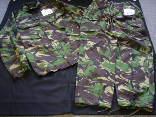 A WOVEN OCCUPATIONAL/INDUSTRIAL ENSEMBLE FOR MEN. BOTH GARMENTS ARE  MADE FROM IDENTICAL CAMOUFLAGE MATERIAL.  THE UPPER GARMENT IS A JACKET WITH A COMPLETE OPENING WITH A LEFT OVER RIGHT BUTTON FASTENING.  WITH A ROUND NECK WITH COLLAR.  WITH LONG SLEEVES WITH ADJUSTABLE BUTTON CUFFS.  WITH A BREAST POCKET EACH SIDE.  HEMMED AT BASE.  THE TROUSERS HAVE A ZIP FLY OPENING WITH A LEFT OVER RIGHT FLAP WITH A BUTTON AT THE TOP.  WITH A DRAWSTRING TIE AT WAIST. WITH ATTACHED BELT LOOPS.  WITH A BUTTON AND TAB TIGHTENING AT BACK.  WITH VARIOUS POCKETS.  HEMMED AT LEG ENDS WITH A DRAWSTRING TIGHTENING.  67% POLYESTER.  33% COTTON.  PACKAGED TOGETHER IN A POLY BAG FOR RETAIL SALE.