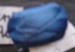 A WOODEN NAPKIN RING, COVERED IN RAYON CORD, IN A PLAITED DESIGN. NOT LAUNDERABLE.