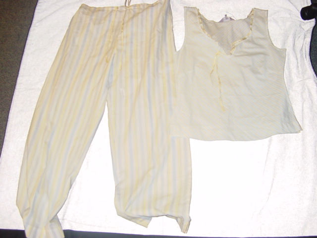 WOVEN PYJAMAS FOR WOMEN.  CONSISTING OF AN VEST STYLE UPPER GARMENT. V-NECK, WITHOUT OPENING.  WITH V NOTCH AT FRONT.  WITHOUT SLEEVES.  HEMMED AT BASE WITH SMALL VENTS IN SIDE SEAMS.  WITH RIBBON DECORATION AT NECKLINE.  PACKED WITH TROUSERS.  CONSTRUCTED OF CO ORDINATING BLUE AND YELLOW STRIPED FABRIC.  ELASTICATED AT BACK OF WAIST. WITH RIBBON DRAWSTRING AT FRONT.  HEMMED AT LEG ENDS. 100% COTTON
