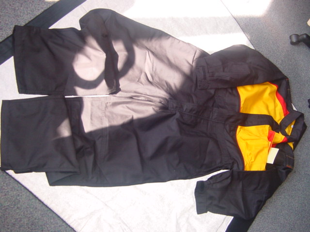 WOVEN INDUSTRIAL OCCUPATIONAL ALL IN ONE COVERALL FOR MEN.   ELASTICATED AT SIDES OF WAIST.  ROUND NECK WITH COLLAR.  COMPLETE FRONT OPENING FASTENED LEFT OVER RIGHT BY ZIP AND VELCRO FLAP.   WITH VARIOUS POCKETS.  LONG SLEEVES WITH VELCRO TIGHTENING AT CUFF.  HEMMED AT LEG ENDS.  WITH REINFORCING PATCHES AT KNEES, AND VELCRO TIGHTENING AT LEG ENDS.  WITH EMBROIDERED LOGO ON CHEST AND BACK.  WITH DOUBLE STITCHED SEAMS.  75% POLYESTER AND 25% COTTON