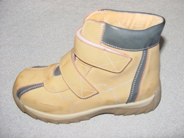 CHILDS BOOT. COVERING THE ANKLE BUT NO PART OF THE CALF. UPPERS OF BEIGE AND GREY PLASTIC.  OUTER SOLE OF RUBBER/PLASTIC. WITH TWO VELCRO FASTENING STRAPS AT THE FRONT OF THE ANKLE.  INSOLE MEASURES LESS THAN 24CM. COMPANY LOGO ON THE TONGUE.