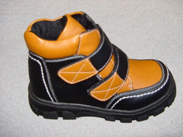 CHILDS BOOT. COVERING THE ANKLE BUT NO PART OF THE CALF. UPPERS OF BLACK AND BROWN PLASTIC.  OUTER SOLE OF HEAVY TREAD RUBBER/PLASTIC. WITH TWO VELCRO FASTENING STRAPS AT THE FRONT OF THE ANKLE.  INSOLE MEASURES LESS THAN 24CM. COMPANY LOGO ON THE TONGUE.