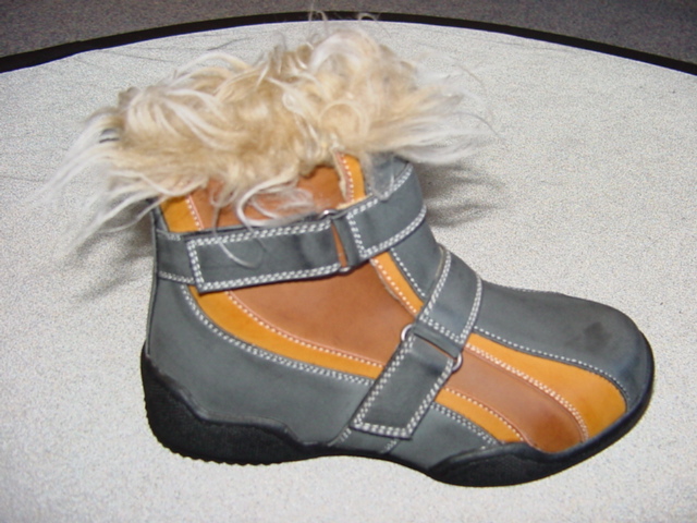 CHILDS BOOT. COVERING THE ANKLE BUT NO PART OF THE CALF. UPPERS OF PLASTIC IN THREE DIFFERENT COLOURS. WITH OUTER SOLE OF RUBBER/PLASTIC. WITH ARTIFICIAL FUR TRIM AROUND THE TOP.  WITH TWO VELCRO FASTENING STRAPS. INSOLE MEASURES LESS THAN 24CM.