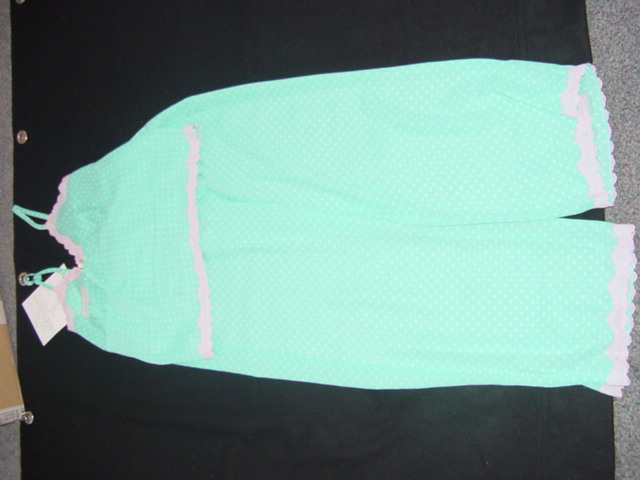 A WOVEN PAIR OF PYJAMAS FOR WOMEN. CONSISTING OF A CAMISOLE WHICH HAS ADJUSTABLE SHOULDER STRAPS  WITH A V-NECK. WITH SHAPED CUPS. WITH LACE TRIM AROUND THE TOP AND BASE OF THE GARMENT. THE BOTTOMS ARE A PAIR OF TROUSERS ENVELOPING EACH LEG SEPARATELY. WITH AN ELASTICATED WAIST BAND. WITH LACE TRIM AT THE LEG ENDS. 100% POLYESTER.