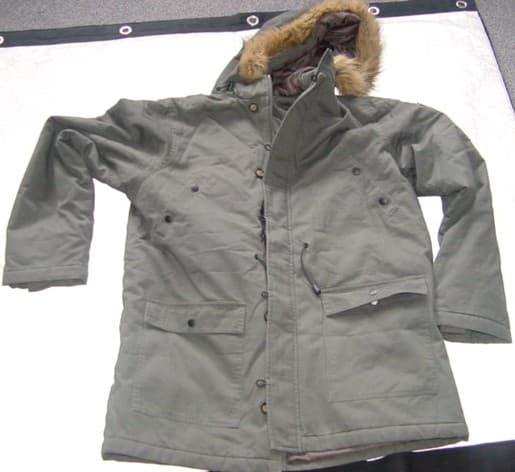 A WOVEN PARKA FOR BOYS. REACHING TO BELOW MID-THIGH. WITH A COMPLETE OPENING WITH A ZIP FASTENER AND A LEFT OVER RIGHT STORM FLAP WITH BUTTON AND LOOP FASTENINGS. WITH A DRAWSTRING HOOD WITH FUR TRIMMING. WITH LONG SLEEVES, HEMMED AT SLEEVE ENDS, WITH INNER RIBBED CUFFS. WITH FOUR POCKETS TO FRONT AND A ZIP AND PEN POCKET TO LEFT SLEEVE. HEMMED AT BASE OF GARMENT. ELASTICATED DRAWSTRING TO WAIST. PADDED WITH A QUILTED LINING. 100% COTTON.
