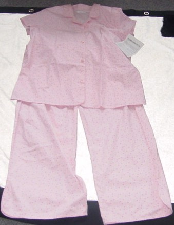 A PAIR OF WOVEN PYJAMAS FOR LADIES. THE UPPER GARMENT IS A PYJAMA STYLE JACKET. DESIGNED TO COVER THE UPPER PART OF THE BODY FROM THE SHOULDERS TO THE UPPER THIGH. WITH A COMPLETE OPENING FASTENED RIGHT OVER LEFT WITH BUTTONS. WITH SHORT SLEEVES. WITH COLLAR. HEMMED. THE LOWER GARMENT IS A PAIR OF LOOSE FITTING TROUSERS DESIGNED TO COVER THE LOWER PART OF THE BODY FROM THE WAIST TO THE ANKLES ENVELOPING EACH LEG SEPARATELY.  WITH A PARTIALLY ELASTICATED WAISTBAND AND A DRAWSTRING TIE. HEMMED. WITH VENTS AT ANKLES. PACKAGED TOGETHER FOR RETAIL SALE. OF 100% COTTON.