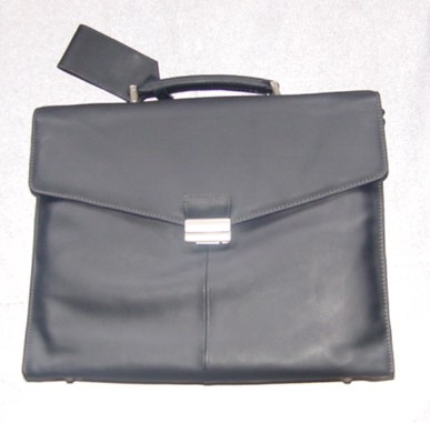 EXECUTIVE CASE MADE FROM LEATHER. MEASURING 40CM IN LENGTH, 32CM HIGH AND 9CM WIDE. WITH CARRY HANDLE WHICH HAS A PRESS STUD ID TAG FASTENED ON. WITH DETACHABLE SHOULDER STRAP. WITH FRONT FLAP WHICH FULLY OPENS AND IS FASTENED BY A CLIP. WITH INNER COMPARTMENT DESIGNED TO HOLD A LAPTOP COMPUTER WITH EXTRA PADDING. WITH EXTRA COMPARTMENT TO HOLD DOCUMENTS. WITH ANOTHER COMPARTMENT ABLE TO HOLD STATIONERY AND OTHER ACCESSORIES. WITH ADDITIONAL SMALL ZIP CASE MADE OF SAME MATERIAL DESIGNED TO CARRY STATIONERY/ACCESSORIES. WITH BACK ZIP COMPARTMENT TO HOLD DOCUMENTS ETC. WITH METAL STUDS AT BASE OF CASE. PACKAGED IN A CLEAR PLASTIC BAG AND CARDBOARD BOX.