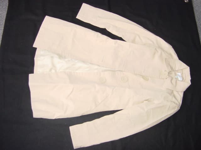 WOVEN COAT FOR WOMEN.  REACHING DOWN TO BELOW MID-THIGH.  LINED.  ROUND NECK WITH COLLAR.  COMPLETE FRONT OPENING FASTENED RIGHT OVER LEFT BY LARGE BUTTONS.  LONG SLEEVES.  HEMMED AT SLEEVE ENDS AND AT BASE OF GARMENT.  WITH POCKETS ON LOWER FRONT.  WEIGHS UNDER 1KG. 100% COTTON
