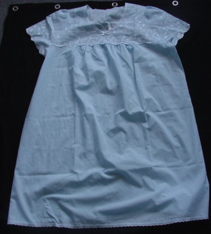WOVEN NIGHTDRESS FOR WOMEN. REACHING FROM THE SHOULDERS TO THE KNEE. WITH ROUND NECK. WITH SHORT SLEEVES. WITH EMBROIDERY ALONG TOP, SLEEVES AND AT BASE OF GARMENT. WITH APPLIED BOW ON CENTRE FRONT OF GARMENT. 100% COTTON.