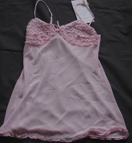 A WOVEN SHORT CHEMISE STYLE NIGHTDRESS  WHICH COVERS THE UPPER PART OF THE BODY TO THE TOP OF THE THIGH. WITH ADJUASTABLE SHOULDER STRAPS. WITH SHAPED CUPS TO THE BUST. WITH FRILLED DECORATION ACROSS THE CUPS. FRILL DECORATION TO BASE OF HEM. 100% POLYESTER.