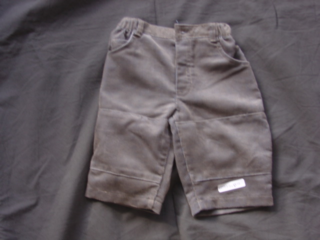 A PAIR OF WOVEN TROUSERS FOR BABIES. DESIGNED TO COVER THE LOWER PART OF THE BODY FROM THE WAIST TO THE ANKLE ENVELOPING EACH LEG SEPARATELY.  WITH A PARTIAL FRONT OPENING WITH LEFT OVER RIGH BUTTON FASTENING. WITH A PARTIAL ELASTICATED WAIST BAND. WITH POCKETS, HEMMED AT LEG ENDS. 60% POLYESTER/ 40% COTTON. 0-3 MONTHS. PACKAGED ON A HANGER WITH A TOP AND SHIRT CLASSIFIED SEPARATELY ( SEE BTI 113354605, 11354409)