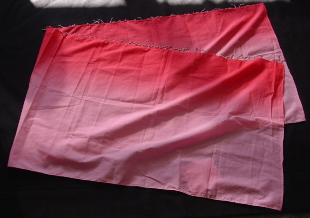 A WOVEN TWO TONE SCARF/SARONG.  A RECTANGULAR PIECE OF MATERIAL  MEASURING 50 X 160 CMS.  APPROX.  HEMMED ON ALL SIDES.  WITH ATTACHED DECORATIVE STRINGS OF BEADS MEASURING 3 CMS. APPROX.  ALONG ONE SIDE.  100% COTTON.