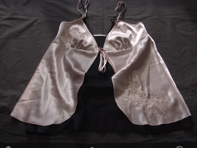 A PAIR OF WOVEN BABYDOLL PYJAMAS. UPPER IS A CHEMISE STYLE GARMENT WITH A SINGLE TIE AT THE BUST. WITH ADJUSTABLE SHOULDER STRAPS.WITH A SHAPED HEM AT BASE OF GARMENT. WITH LACE AND SEQUIN APPLIQUES TO FRONT. MADE OF TWO LAYERS OF CONTRASTING FABRIC. WITH A MATCHING TANGA BRIEF,WITH A LINED GUSSET, WITH TIES AT THE SIDES. WITH CONTRASTING LACE TRIM,  AND APPLIQUE TO FRONT.100% POLYESTER SATIN.