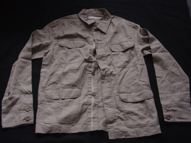 A WOVEN JACKET FOR MEN.  DESIGNED TO COVER THE UPPER PART OF THE BODY FROM THE SHOULDERS TO THE HIP.  WITH A COMPLETE OPENING WITH A LEFT OVER RIGHT BUTTON FASTENING WITH A FLAP OVER.  WITH LONG SLEEVES WITH A TWO BUTTONED CUFF.  WITH A BREAST POCKET EACH SIDE AND A POCKET EACH SIDE ON LOWER FRONT, ALL WITH A FLAP.  HEMMED AT BASE.  100%  RAMIE.