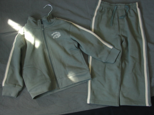 KNITTED TRACKSUIT FOR UNISEX.  CONSISTING OF A WIND-JACKET.  REACHING DOWN TO BELOW THE WAIST.  ROUND NECK WITH COLLAR.  COMPLETE FRONT OPENING FASTENED BY ZIP.  LONG SLEEVES. WITH RIBBING AT SLEEVE ENDS AND AT BASE.  WITH POCKETS ON LOWER FRONT.  EMBROIDERED LOGO ON LEFT CHEST.  WITH APPLIED CONTRASTING STRIPS DOWN SLEEVES.  WITH TROUSERS OF SAME FABRIC.  ELASTICATED WAIST. WITHOUT OPENING WITH MOCK DRAWSTRING.  HEMMED AT LEG ENDS.  WITH APPLIED CONTRASTING STRIPS DOWN SIDE SEAMS.  100% COTTON.  PACKED WITH A T-SHIRT CLASSIFIED SEPARATELY.