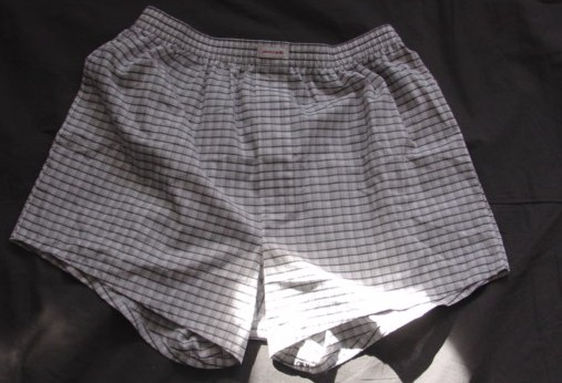 A PAIR OF WOVEN BOXER SHORTS FOR MEN. WITH AN ELASTICATED WAIST. WITH A LEFT OVER RIGHT FLY WITHOUT ANY FASTENING. HEMMED AT LEG ENDS. 60% COTTON / 40% POLYESTER CHECK FABRIC.
