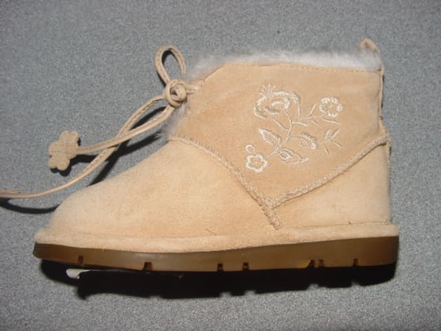 TODDLERS/CHILDS ANKLE BOOT. COVERING THE ANKLE BUT NO PART OF THE CALF. UPPERS OF LEATHER (SUEDE). EMBROIDERED FLOWER DESIGN ON THE SIDE. OUTER SOLE OF RUBBER. LACE FASTENING AT THE FRONT OF THE ANKLE. INSOLE LENGTH LESS THAN 24CM. BEIGE IN COLOUR. WITH FUR FABRIC LINING