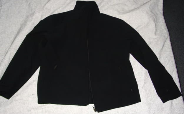 A WOVEN JACKET FOR MEN. REAHING TO BELOW THE WAIST. WITH A COMPLETE OPENING WITH A ZIP FASTENER. WITH A STAND-UP COLLAR WITH A LEFT OVER RIGHT TAB, WITH BUTTON FASTENING. WITH LONG SLEEVES, WITH DECORATIVE TABS. HEMMED AT SLEEVE ENDS AND BASE OF GARMENT. DIAGONAL ZIP POCKETS TO LOWER FRONT AND ONE INNER POCKET. FULLY LINED. 65% POLYESTER / 35% COTTON.