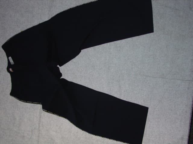 A CHILDS KNITTED PAIR OF TROUSERS. DESIGNED TO COVER THE LOWER PART OF THE BODY FROM THE WAIST TO THE ANKLE ENVELOPING EACH LEG SEPARATELY. WITH AN ELASTICATED WAISTBAND. WITH PIPING DOWN EACH LEG. HEMMED. 100% COTTON. PRESENTED WITH A T-SHIRT CLASSIFIED SEPARATELY ( SEE BTI 113524705)