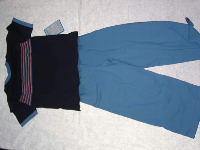 A CHILDS KNITTED PAIR OF PYJAMAS FOR UNISEX. CONSISTING OF AN UPPER AND LOWER GARMENT. THE UPPER HAS SHORT SLEEVES. WITH A ROUND NECK. WITH A STRIPE DESIGN ON THE FRONT. HEMMED. THE LOWER CONSISTS OF A PAIR OF TROUSERS ENVELOPING EACH LEG SEPARATELY. WITH AN ELASTICATED WAISTBAND WITH DRAWSTRING TIGHTENING. HEMMED AT LEG ENDS. 1005 COTTON.